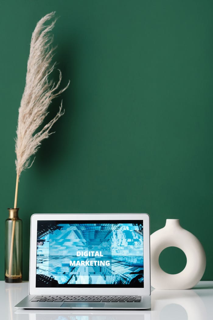 Laptop displaying digital marketing on screen with decorative items on a desk.